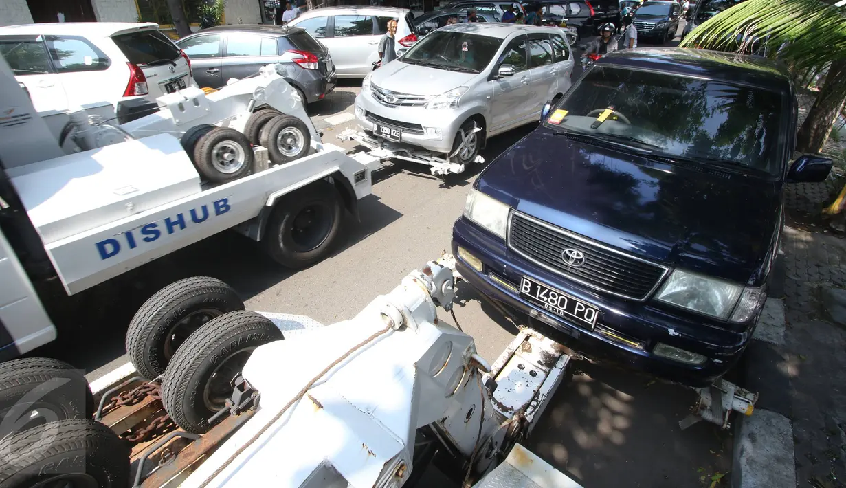 Petugas Dishub menderek kendaraan yang parkir liar di kawasan Pasar Baru, Jakarta, Kamis (7/1). Pemprov DKI berencana menaikan denda Rp 3 juta per hari terhadap kendaraan yang terjaring parkir liar. (Liputan6.com/Immanuel Antonius)