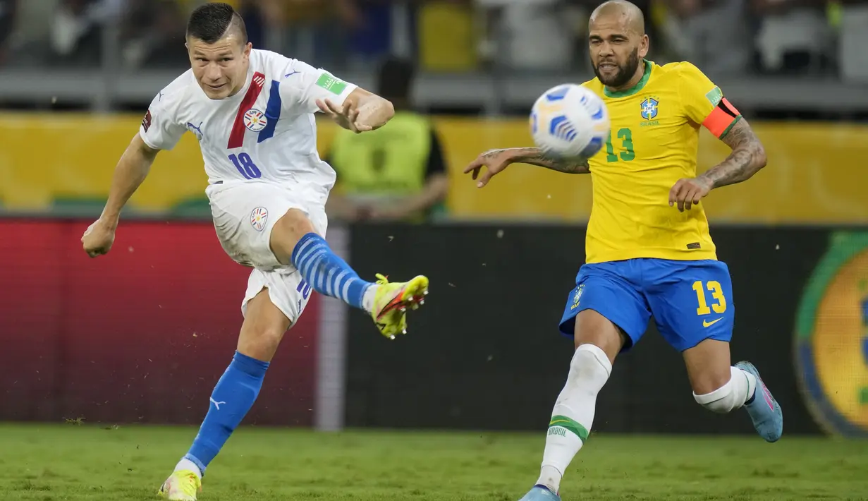 Pemain Paraguay, Braian Samudio menendang bola dari kawalan bek Brasil, Dani Alves pada laga Kualifikasi Piala Dunia 2022 zona CONMEBOL di stadion Mineirao di Belo Horizonte, Brasil, Rabu (2/2/2022). Brasil menang atas Paraguay 4-0. (AP Photo/Andre Penner)