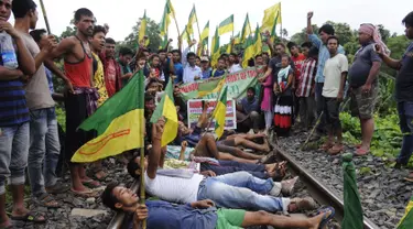Ratusan pengunjuk rasa dari Front Rakyat Pribumi Tripura (IPFT) melakukan pemblokiran jalur rel kereta api saat menggelar demo di Khamtingbari di dekat perbatasan Agartala, India, Senin (10/7). (AFP Photo/ Arindam Dey)