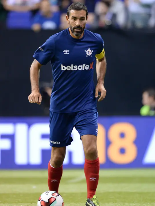 Pemain Prancis Robert Pires mengiring bola saat bertanding melawan Denmark pada final turnamen Star Sixes di O2 Arena di London (16/7). Prancis menang atas Denmark 2-1 dan menjadi juara turnamen ini. (AFP Photo/Olly Greenwood)