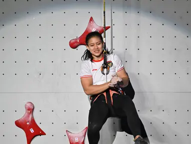 Reaksi atlet panjat tebing Indonesia Desak Made Rita Kusuma Dewi usai mengalahkan Deng Lijuan dari China pada final speed putri Asian Games 2022 di Hangzhou, China, Selasa (3/10/2023). (ADEK BERRY / AFP)