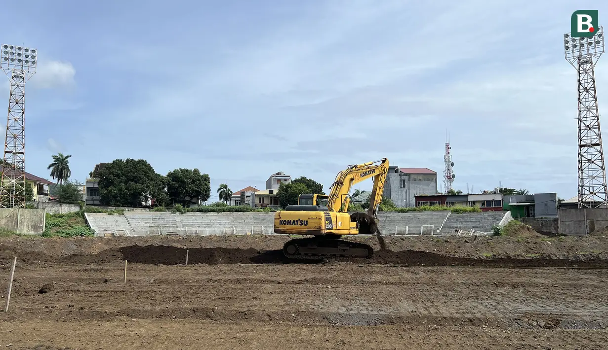 Sebuah ekskavator sedang melakukan renovasi pada bagian lapangan Stadion Gelora Kie Raha yang terletak di Ternate, Maluku Utara pada Kamis, (14/3/2024). Stadion tersebut akan menjadi markas bagi Malut United untuk Liga 1 musim depan. (Bola.com/Hery Kurniawan)