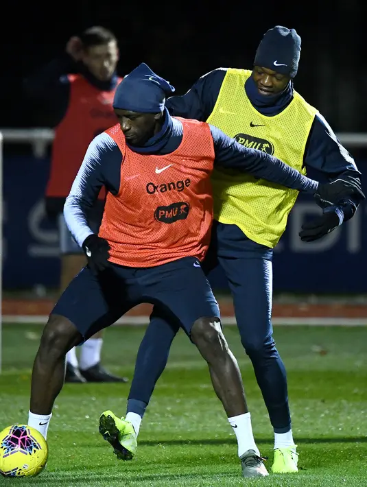 Pemain Prancis Benjamin Mendy (kiri) berebut bola dengan Steve Mandanda saat sesi latihan jelang menghadapi Moldova dan Albania pada babak kualifikasi Grup H Piala Eropa 2020 di Clairefontaine-en-Yvelines, Prancis, Selasa (12/11/2019). (FRANCK FIFE/AFP)