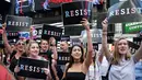 Pendemo membawa poster dalam aksi mengecam Donald Trump terkait larangan transgender masuk militer AS di Times Square, New York, Rabu (26/7). Pentagon mengatakan akan memberikan panduan revisi ke departemen dalam waktu dekat. (AP/Frank Franklin II)