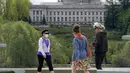 Pejalan kaki dengan masker dan tanpa masker berjalan di dekat Capitol di Olympia, Washington, Selasa (27/4/2021). Warga Amerika Serikat (AS) yang telah menerima vaksin COVID-19 tidak lagi diwajibkan mengenakan masker saat berada di luar ruangan jika tidak ada kerumuman. (AP Photo/Ted S. Warren)