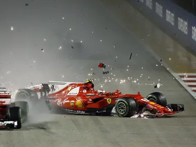 Pebalap Ferrari, Kimi Raikkonen (kanan) mengalami kecelakaan saat balapan F1 GP Singapura di Marina Bay City Circuit (17/9/2017). Duo pebalap Ferrari gagal melanjutkan balapan. (AP/Yong Teck Lim)