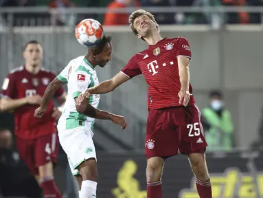 Penyerang Bayern Munchen Thomas Muller (kanan) dan gelandang Greuther Fuerth, Julian Green pada pekan keenam Liga Jerman 2021/2022 di Trolli Arena, Sabtu (25/9/2021) dini hari WIB. Die Roten –julukan Bayern Munchen – menang 3-1 atas tim promosi Greuther Furth. (Daniel Karmann/dpa via AP)