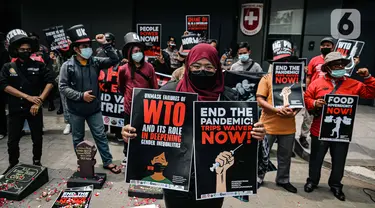 Massa gabungan organisasi masyarakat sipil Koalisi Gerak Lawan membawa poster saat demo di Kedutaan Besar Swiss, Jakarta, Selasa (30/11/2021). Aksi tersebut bertujuan mengecam kehadiran World Trade Organization (WTO) dengan kebijakan yang merugikan nasib rakyat kecil. (Liputan6.com/Faizal Fanani)