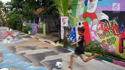 Anak-anak bermain bola di sebuah gang di Kinayungan, Tangsel, Kamis (28/6). Warga di perumahan tersebut menghias lingkungannya menjadi "Kampung Piala Dunia" guna menyemarakan perhelatan sepak bola Piala Dunia 2018 di Rusia. (Merdeka.com/ Arie Basuki)