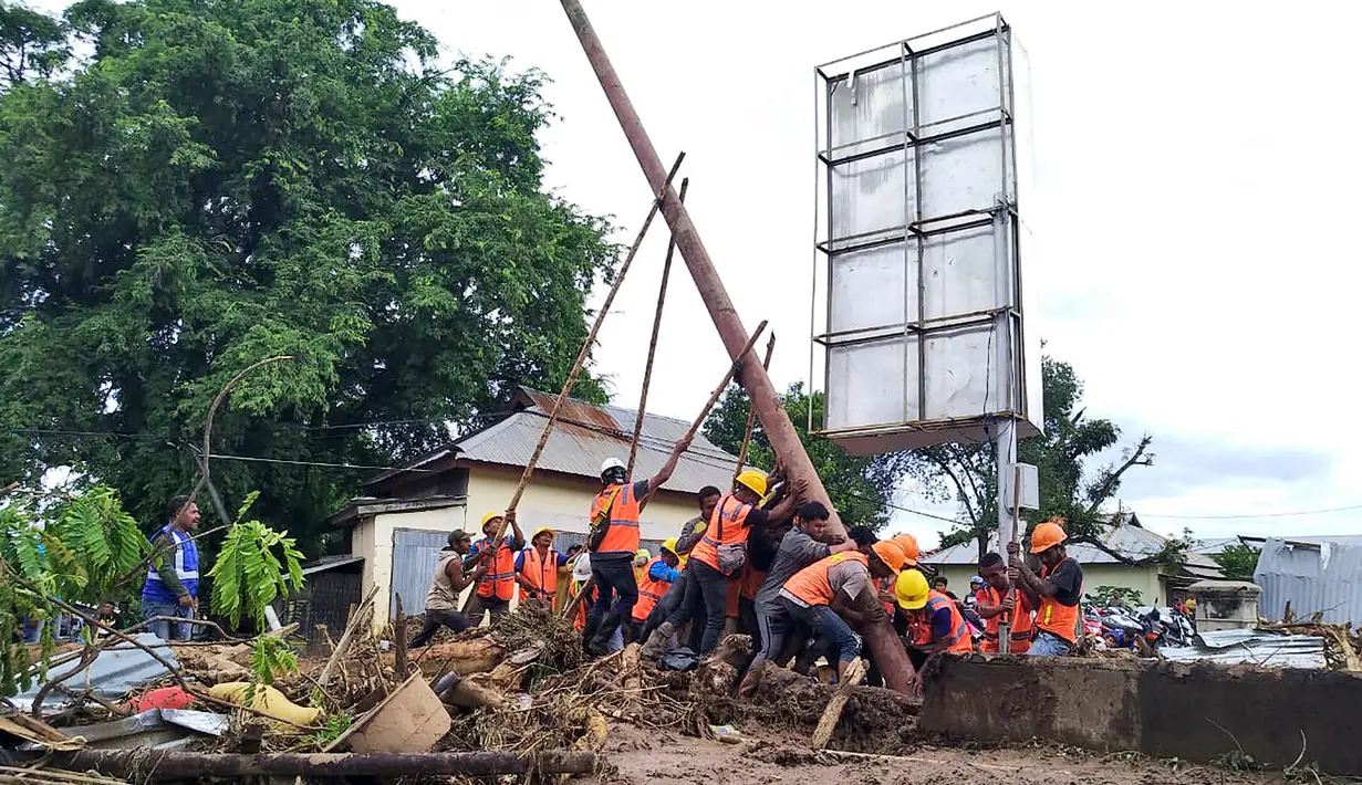 Pekerja memperbaiki tiang listrik di daerah yang terkena banjir bandang di Waiwerang, Pulau Adonara, Nusa Tenggara Timur, Selasa (6/4/2021). Tim penyelamat terus menggali puing tanah longsor untuk mencari korban yang terkubur usai bencana banjir bandang. (AP Photo/Rofinus Monteiro)