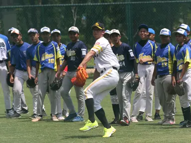 Atlet Baseball dari tim Softbank Hawks, Shuhei Fukuda memberikan contoh melempar saat Asia Baseball Clinic di Lapangan Baseball GBK, Jakarta, Rabu (19/12). Program ini untuk meningkatkan skill atlet Baseball di Indonesia. (Liputan6.com/Helmi Fithriansyah)