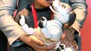 Seorang anak bermain dengan robot anjing dari Sony, Aibo yang telah ia beli saat acara peresmian di Tokyo, Jepang (11/1). Menurut pihak Sony, robot Aibo baru ini dapat membentuk ikatan emosional dengan pemiliknya. (AFP Photo/Kazuhiro Nogi)