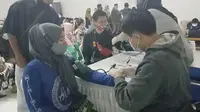 Beberapa petugas vaksinator kelurahan Kota Wetan Garut Kota tengah melakukan vaksinasi Covid-19 warga Garut, Jawa Barat pada malam hari. (Liputan6.com/Jayadi Supriadin)