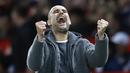 Pelatih Manchester City, Pep Guardiola, merayakan kemenangan atas Manchester United pada laga Premier League di Stadion Old Trafford, Rabu, (24/4). Manchester United takluk 0-2 dari Manchester City. (AP/Martin Rickett)
