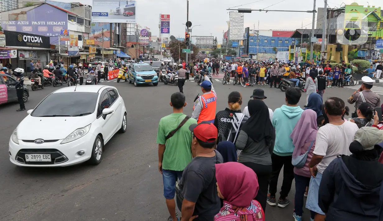 Pihak kepolisian kota Depok bersama instansi terkait menerapkan sistem lawan arah atau contraflow di sebagian Jalan Margonda Raya, kota Depok, Jawa Barat, Minggu (4/5/2025). (Liputan6.com/Herman Zakharia)