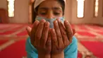 Seorang anak yatim Muslim mengenakan masker berdoa sambil menjaga jarak sosial di dalam pusat panti asuhan selama bulan suci Ramadan di Srinagar (11/5/2020). (AFP/Tauseff Mustafa)