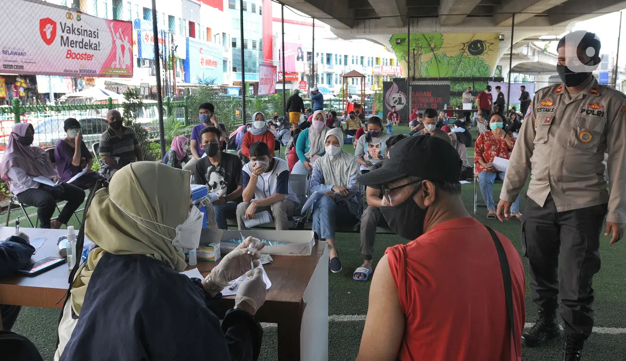 Vaksinator menyuntikkan vaksin dosis ketiga kepada seorang pria di kolong flyover Ciputat, Tangerang Selatan, Sabtu (2/4/2022). Vaksinasi booster tersebut diselenggarakan oleh Polsek Ciputat Timur dan Polres Tangerang Selatan. (merdeka.com/Arie Basuki)