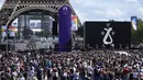 Penonton menyaksikan Woodkid tampil di atas panggung di zona penggemar Olimpiade di Taman Trocadero di depan Menara Eiffel di Paris, Minggu (8/8/2021). Paris akan menjadi tuan rumah Olimpiade Musim Panas berikutnya pada tahun 2024. (AP Photo/Francois Mori)