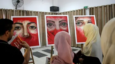 Orang-orang mengunjungi pameran seniman Palestina Kholoud al-Dasooqi di Gaza City, 11 Agustus 2020. Seniman Palestina asal Kota Khan Younis di Jalur Gaza itu menggelar pameran selama dua hari untuk mengungkap kekerasan terhadap perempuan melalui puluhan lukisan. (Xinhua/Rizek Abdeljawad)