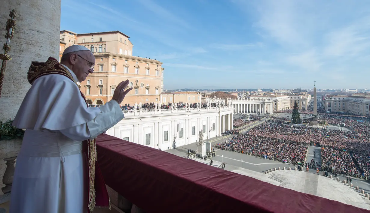 Paus Francis berdiri di balkon Basilika St Peter saat menyampaikan pesan Natal, Vatikan (25/12/2015). (AFP Photo/ Osservatore Romano)