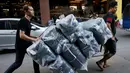 Pedagang membawa karung berisi T-shirt hitam untuk didistribusikan ke sejumlah toko untuk pembeli di Pasar Grosir Bo Bae Bangkok, Thailand (15/10). (REUTERS / Edgar Su)