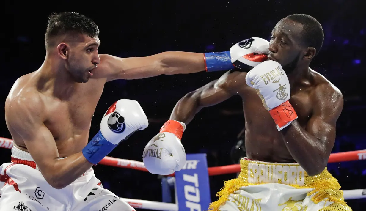 Amir Khan (kiri) meninju Terence Crawford pada perebutan gelar juara dunia tinju kelas welter WBO di Madion Square Garden, New York, Amerika Serikat, Minggu (21/4) . Crawford unggul sejak ronde pertama atas Khan. (AP Photo/Frank Franklin II)