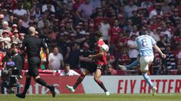 Pemain Manchester City, Ilkay Gundongan (kanan), menendang bola ke gawang Manchester United  yang membuahkan gol cepat di detik ke-12 dalam pertandingan final FA Cup 2022/2023 yang berlangsung di Wembley Stadium, Sabtu (3/6/2023). (AP Photo/Dave Thompson)