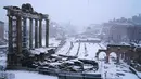 Bangunan kuno yang tertutup salju tebal di Roma, Italia (26/2). Badai salju yang melanda Italia menganggu transportasi dan sekolah diliburkan. (AFP Photo/Vicenzo Pinto)