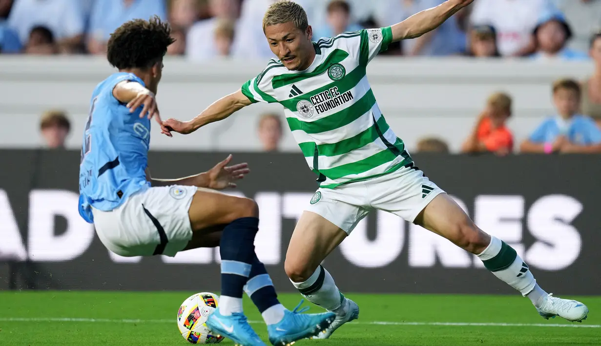Pemain Glasgow Celtic, Kyogo Furuhashi, berusaha melewati pemain Manchester City, Rico Lewis, pada laga uji coba di Stadion Kenan Memorial, Rabu (24/7/2024). (AFP/Grant Halverson)