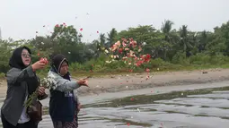 Keluarga menaburkan bunga ke laut dalam prosesi untuk lima jurnalis dan tiga kru kapal Arupadhatu 1 di pantai dekat Dermaga Pegedongan, Banten, Jumat (18/9/2026). Dermaga tersebut menjadi titik awal keberangkatan delapan orang itu pada Senin (7/9/2026). (KLY/Budy Santoso)