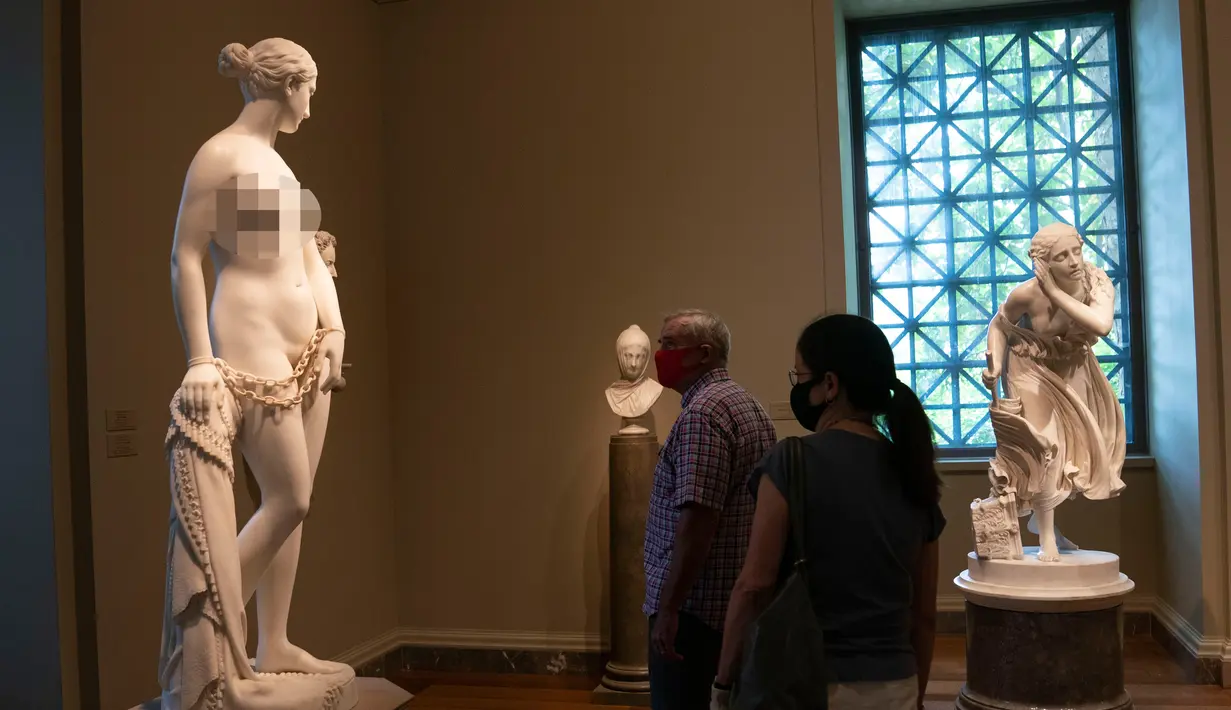 Pengunjung yang mengenakan masker melihat-lihat karya seni yang dipamerkan di Gedung Barat Galeri Seni Nasional di Washington DC, AS (20/7/2020). Sebagian galeri tersebut dibuka kembali untuk umum pada Senin (20/7) setelah ditutup selama berbulan-bulan akibat pandemi COVID-19. (Xinhua/Liu Jie)