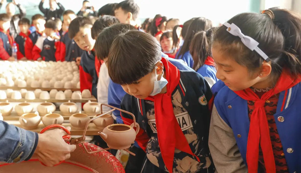 Sejumlah siswa sekolah dasar melihat proses pembuatan porselen di bengkel kerja porselen Ru di Baofeng, Provinsi Henan, China, 15 November 2020. Lebih dari 90 siswa SD Xichengmen mengikuti kegiatan praktik di bengkel kerja itu untuk belajar tentang porselen Ru. (Xinhua/He Wuchang)