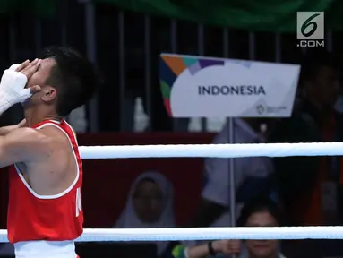 Petinju putra Indonesia, Sunan Agung Amoragam usai melawan Mirazizbek Mirzakhalilov (Uzbekistan) pada semifinal kelas bantam 56kg putra Asian Games 2018 di JIEXPO Kemayoran, Jumat (31/8). Sunan Agung Amoragam kalah 0-5. (Liputan6.com/Helmi Fithriansyah)