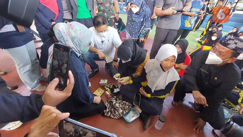 Budi Gunadi Sadikin Mendampingi Seorang Siswi di SMK Negeri 1 Cibinong Saat Ambil Darah Guna Mengetahui Apakah Berisiko Anemia atau Tidak