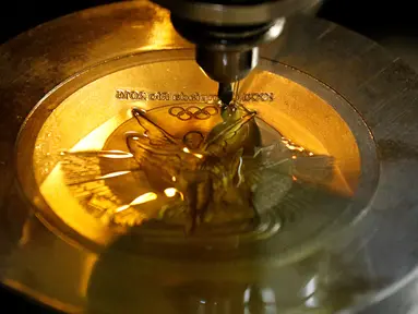 Sebuah mesin membuat ukiran pada bagian medali untuk Olimpiade Rio 2016 di Casa da Moeda do Brasil (Brazilian Mint), Rio de Janeiro, Brasil, (28/6). Sekitar 5.130 medali akan diselesaikan dalam waktu dua hari. (REUTERS/Sergio Moraes)