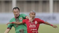 Gelandang Kalteng Putra, Yoo Hyun- Koo berebut bola dengan gelandang Persija Jakarta, Riko Simanjuntak, pada laga Liga 1 2019 di Stadion Madya, Jakarta, Selasa (20/8). Persija menang 3-0 atas Kalteng Putra. (Bola.com/M Iqbal Ichsan)