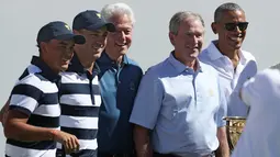 Mantan Presiden AS, Bill Clinton, George W. Bush dan Barack Obama berfoto bersama tim Amerika pada pembukaan pertandingan golf President Cup di New Jersey, Kamis (28/9). Pertama kalinya tiga presiden datang bersama di turnamen ini. (Rob Carr/AFP)