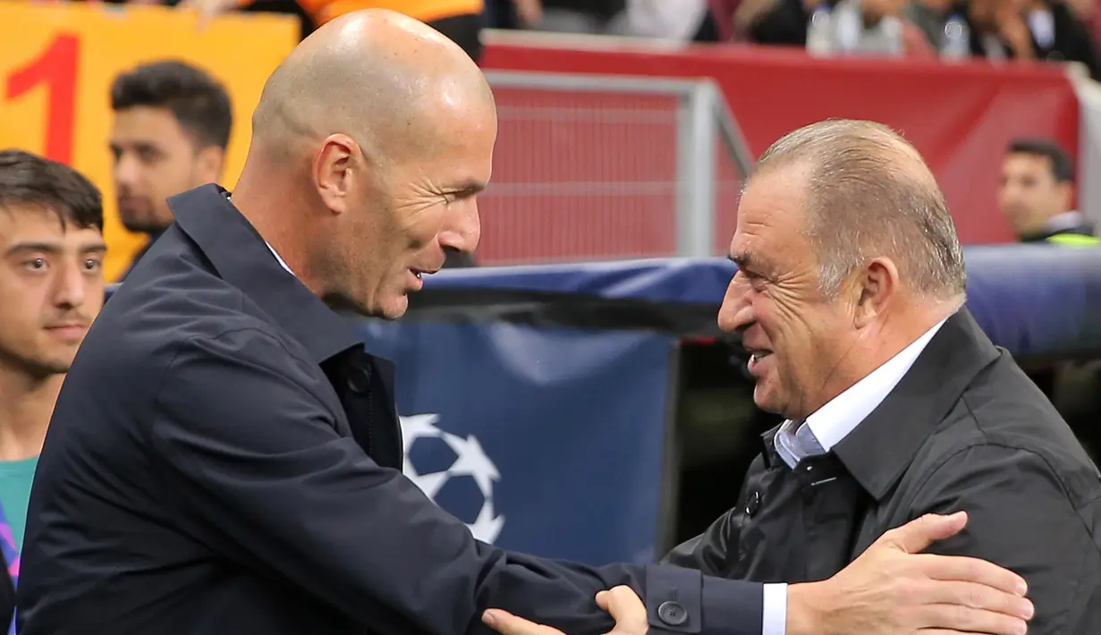 Pelatih Real Madrid Zinedine Zidane (kiri) berbicara dengan Manajer Galatasaray Fatih Terim jelang bertanding pada laga Liga Champions di Istanbul, Turki, Selasa (22/10/2019). Real Madrid mengalahkan Galatasaray lewat gol tunggal Toni Kroos. (AP Photo)