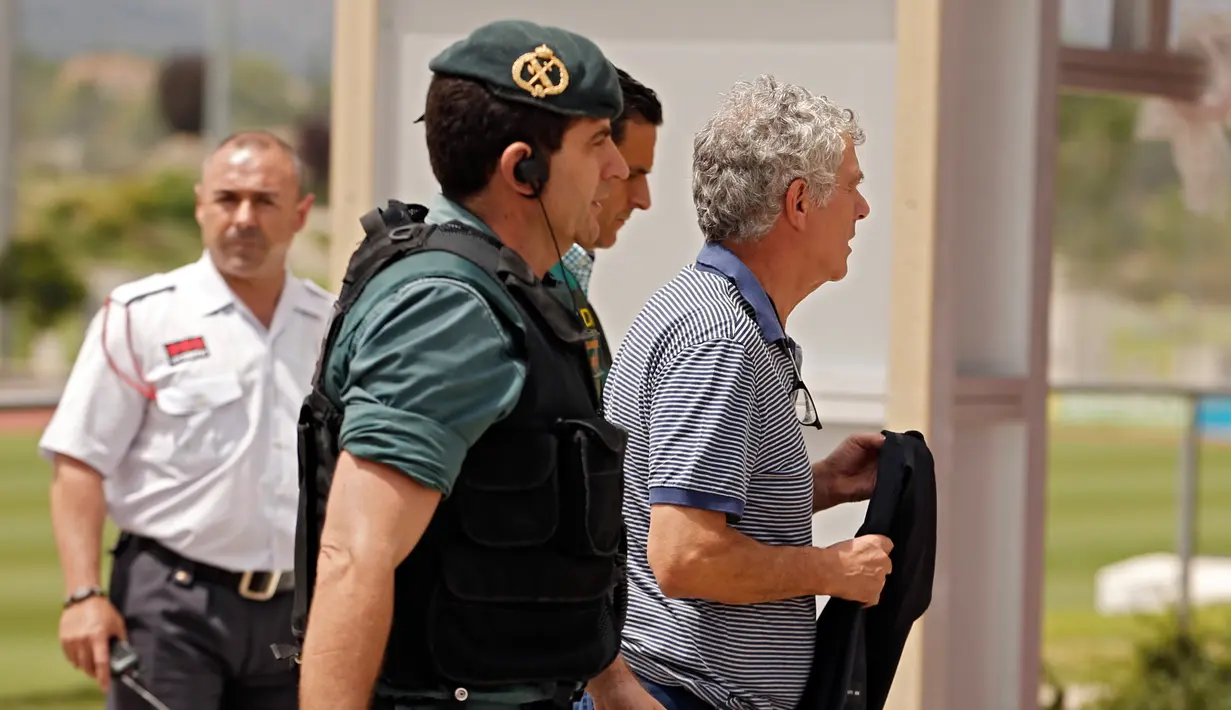 Polisi Spanyol mengawal Angel Maria Villar saat dibawa ke markas besar Federasi di Las Rozas, Spanyol (18/7). Villar terlibat kasus pemalsuan dokumen serta penyalahgunaan wewenang yang melibatkan kepentingan timnas Spanyol. (AP Photo / Francisco Seco)