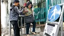 Warga nekat melewati JPO Polda meski telah dipasangi pagar dan diberikan tanda penutupan sementara JPO, Jakarta, Rabu (11/11/2015). Penutupan dilakukan karena jalan di dekat tiang JPO amblas. (Liputan6.com/Yoppy Renato)
