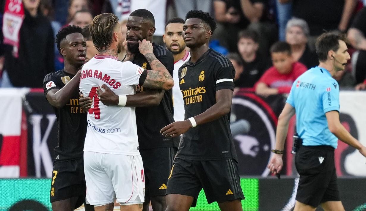 Pemain Sevilla, Sergio Ramos, mencubit pipi pemain Real Madrid, Antonio Rudiger, pada laga Liga Spanyol di Stadion Ramon Sanchez Pizjuan, Sabtu (21/10/2023). (AP Photo/Jose Breton)