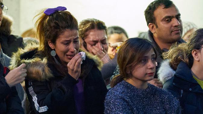 Seorang perempuan menangis saat kebaktian untuk empat mahasiswa pascasarjana korban pesawat 737-800 Ukraina yang jatuh di Iran, di salah satu universitas di Ontario, Kanada, Rabu (8/1/2020). Pesawat yang membawa 176 orang itu jatuh setelah lepas landas dari bandara utama Teheran. (Geoff Robins/AFP)