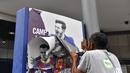 Seorang pekerja melepas poster-poster yang menampilkan pemain depan Barcelona Lionel Messi di stadion Camp Nou di Barcelona (10/8/2021). Prancis menunggu dengan tidak sabar Lionel Messi dengan para pendukung berkumpul di luar lapangan Paris Saint-Germain. (AFP/ Pau Barrena)