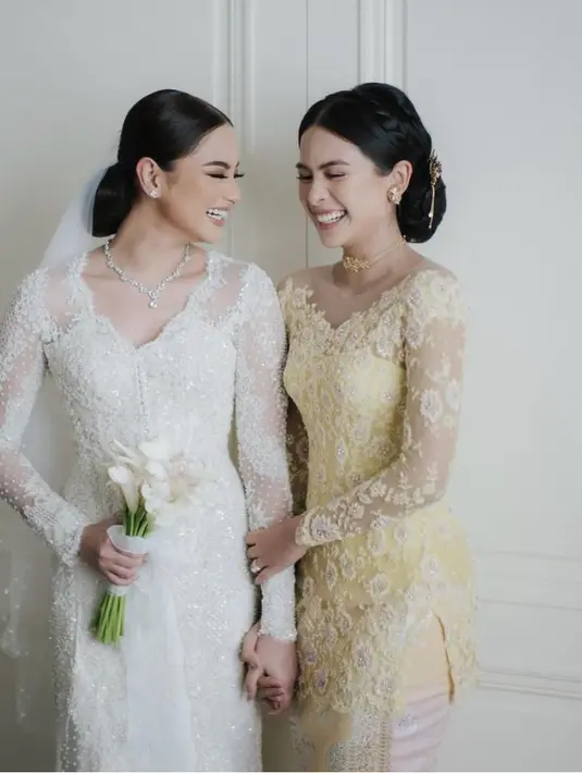 Di pernikahan sang adik, Maudy Ayunda mengenakan kebaya model off shoulder warna kuning dengan embroidery bunga dipadukan kain songket warna senada. [@svarna_byikatindonesia]