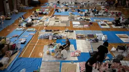 Para pengungsi beristirahat di lokasi pengungsian di Mabi, Prefektur Okayama, Jepang, Rabu (11/7). Pemerintah Jepang menyatakan banjir disertai tanah longsor telah menewaskan 179 orang. (Martin BUREAU/AFP)