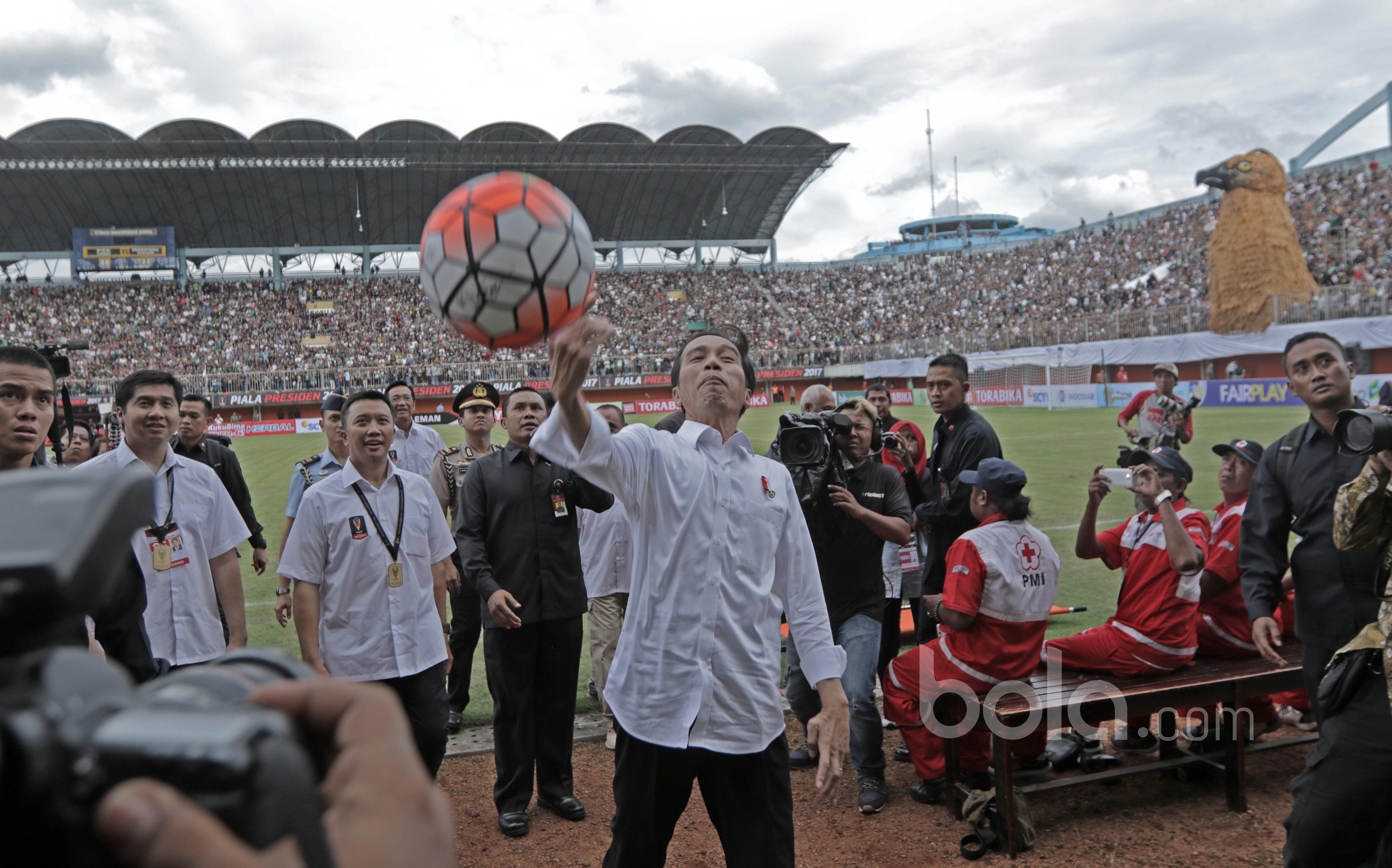 Presiden Republik Indonesia, Joko Widodo membagikan bola kepada penonton tanda saat membuka Piala Presiden 2017 di Stadion Maguwoharjo, Sleman, Sabtu (4/2/2017). (Bola.com/Nicklas Hanoatubun)