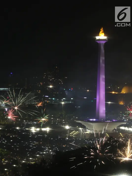 Kembang api menyala menyambut pergantian tahun 2018 ke 2019 di kawasan Monumen Nasional, Jakarta, Selasa (1/1). Hujan yang mengguyur Jakarta tidak menyurutkan warga menikmati kembang api tahun baru. (Liputan6.com/Helmi Fithriansyah)