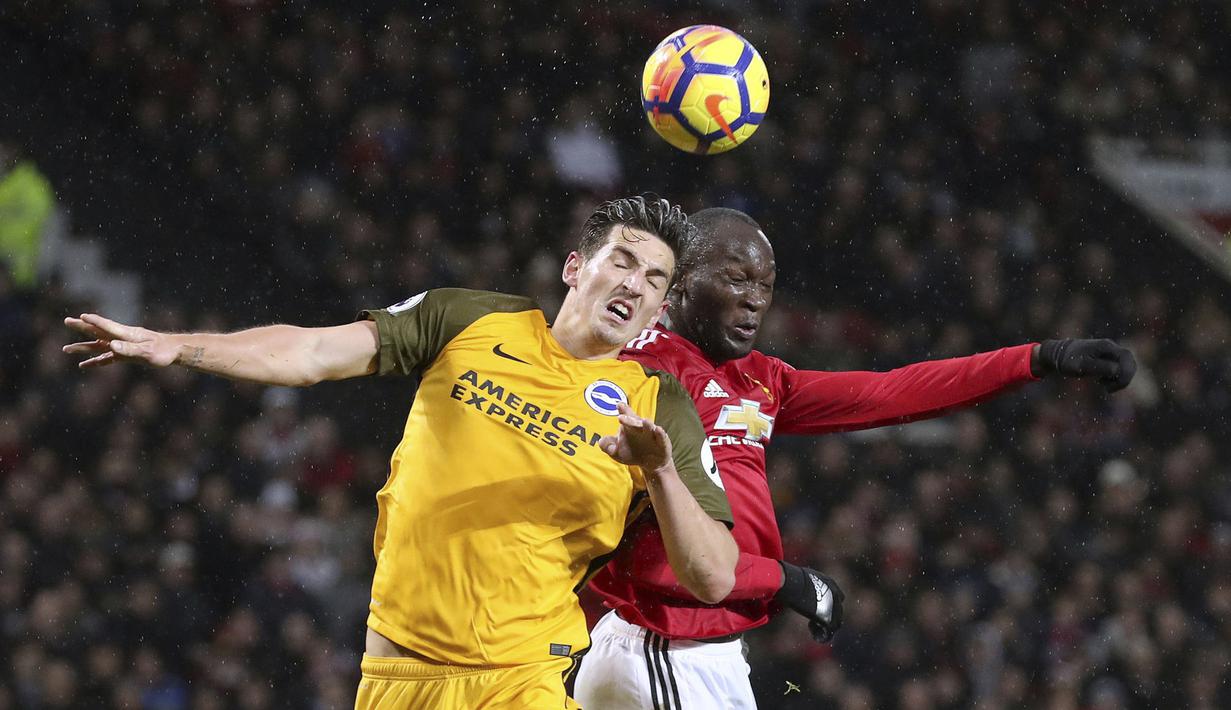 Duel pemain Brighton, Lewis Dunk (kiri) dan pemain Manchester United, Romelu Lukaku pada lanjutan Premier League di Old Trafford, Manchester,(25/11/2017). Manchester United menang tipis 1-0. (Martin Rickett/PA via AP)