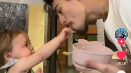 Dali bermain-main dengan sang anak sambil menyuapi. Dia mencium tangan sang buah hati tercinta. (Foto: TikTok/ dali.wassink)