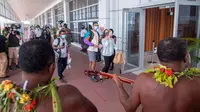 Penari tradisional dengan rok rumput menyambut wisatawan di Nadi, Fiji, Rabu (1/12/2021). Fiji membuka perbatasannya untuk pelancong internasional pertama kalinya sejak pandemi Covid-19 melanda dunia dan menghancurkan ekonominya yang bergantung pada pariwisata. (Handout/TOURISM FIJI/AFP)